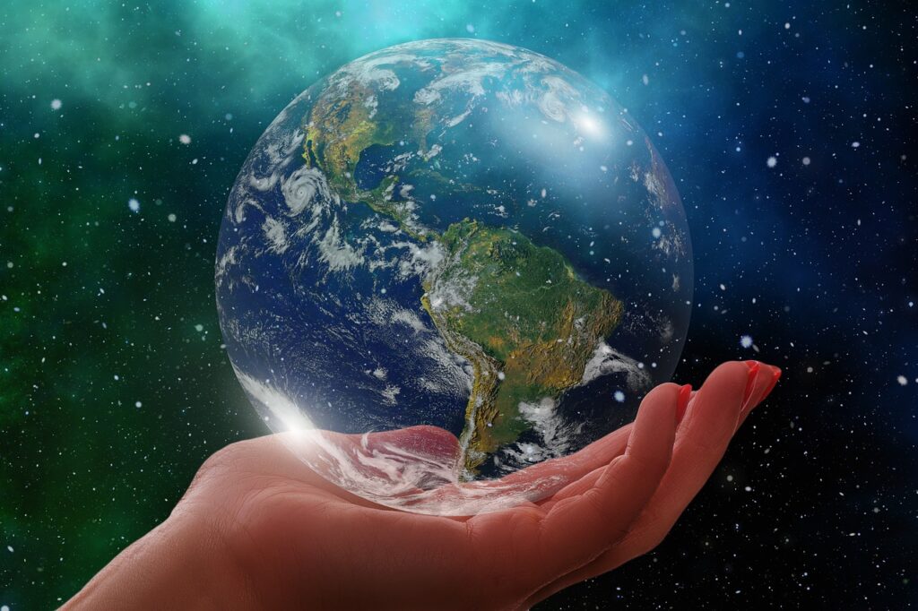 Hand holding a glass globe with cosmic background